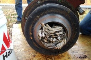 A man is scrubbing a tire with a bucket, demonstrating proper vehicle maintenance and care